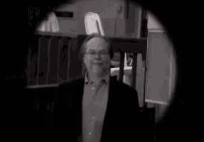 a black and white photo of a man in a suit walking down stairs .