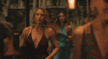 a woman in a red dress is walking down a street with another woman