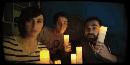 a group of people are holding candles in their hands