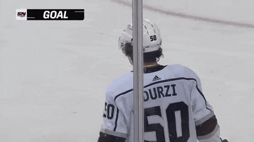 a hockey player with the number 50 on his back is standing on the ice .