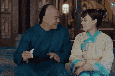 a man and a woman are sitting next to each other looking at each other