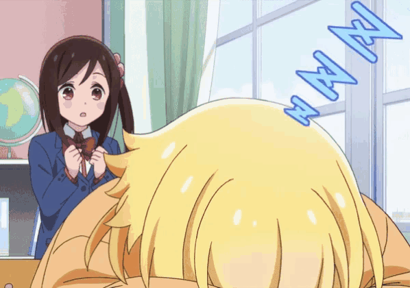 a girl in a school uniform stands next to a girl laying on the floor with a globe behind her
