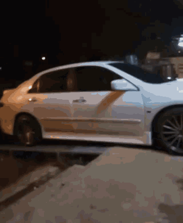 a white car is parked on the side of the road