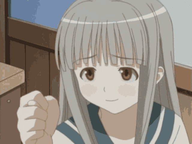 a girl with gray hair and brown eyes is smiling and giving a fist bump