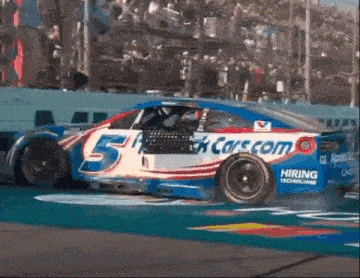 a race car with the number 5 on it is driving down a track .