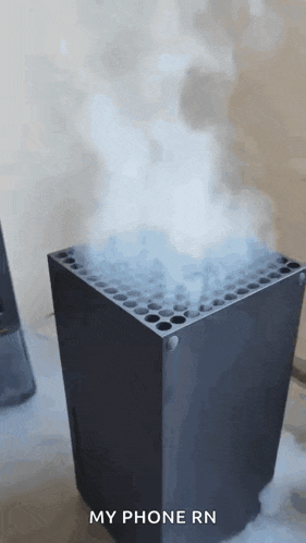 a black box with smoke coming out of it and the words `` my phone rn '' written on the bottom .