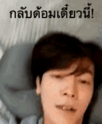 a man is laying on a bed with a pillow and a foreign language .