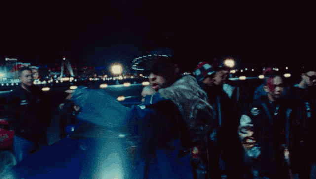 a group of people are standing around a man in a black jacket