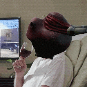 a person wearing a ninja turtle mask is drinking wine