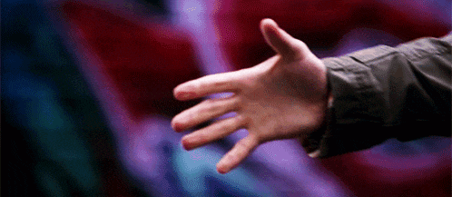 a close up of a person 's hand reaching out towards a red and blue background .