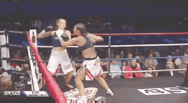 two women are fighting in a boxing ring with axstv on the bottom of the screen