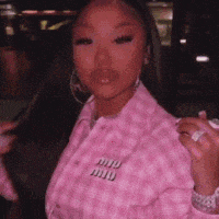 a woman is wearing a pink jacket and holding a pink object in her hand .