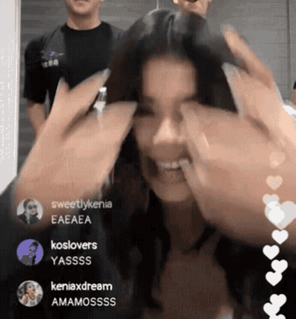 a woman covering her face with her hands in front of a group of people including sweetlykenia