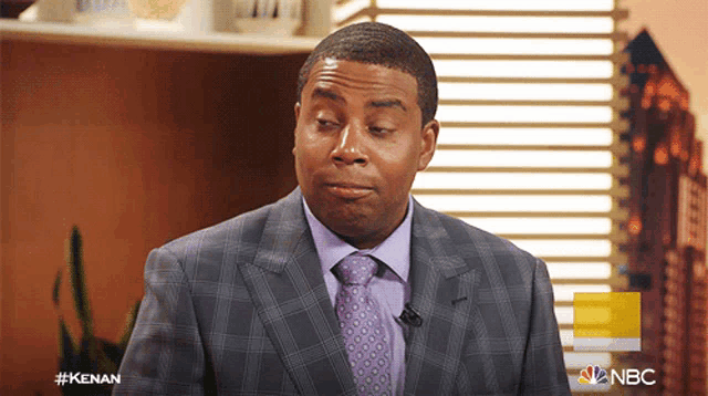 a man in a suit and tie with a nbc logo behind him