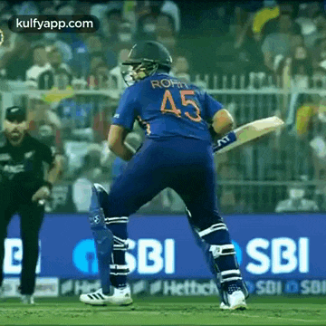 a cricket player is standing on a field with a bat .