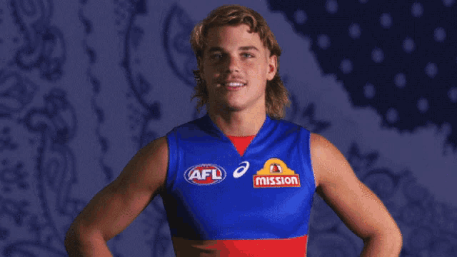 a young man wearing a blue tank top with afl and mission logos on it