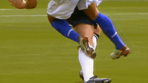a soccer player is being tackled by another player on the field