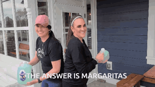 two women standing in front of a building with the answer is margaritas written on the bottom