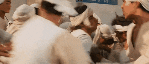 a group of people with bandages on their heads are standing around a man in a hospital bed .