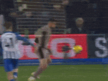 a soccer player wearing a number 21 jersey kicks a soccer ball