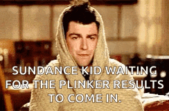 a man with a scarf wrapped around his head is waiting for the plinker results to come in .