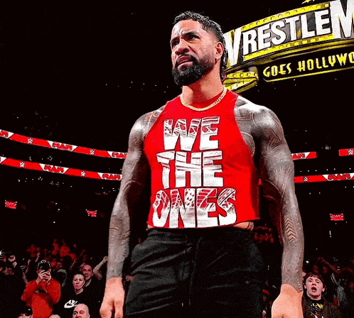 a wrestler in a red tank top that says we the ones