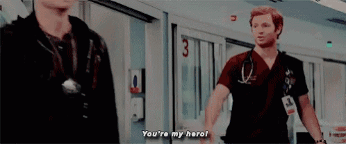 a man with a stethoscope is walking down a hospital hallway with a woman .