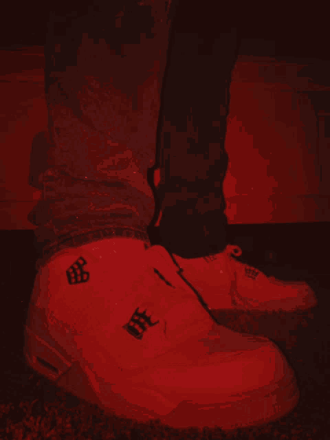 a person is wearing a pair of white sneakers with a black logo on the side