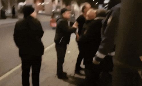 a blurry photo of a group of people standing on the sidewalk
