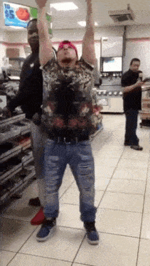 a man is dancing in a store with his arms up