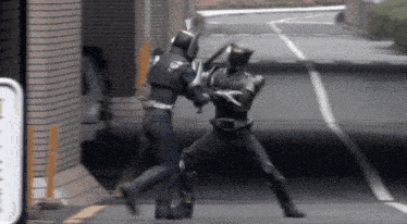 a man in a superhero costume is fighting another man on the street