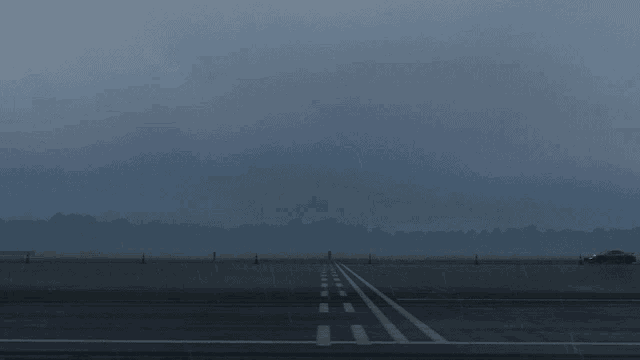 a plane is taking off from a runway in the fog