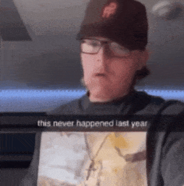 a man wearing a hat and glasses says this never happened last year on a screen