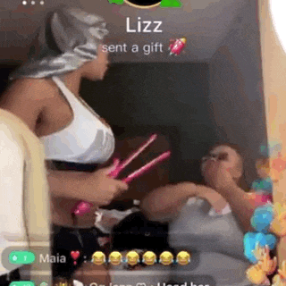 a woman is holding a pair of hair straighteners in front of a mirror while another woman looks on .