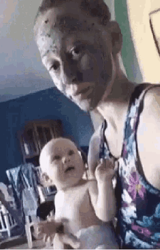 a man with a mask on his face is holding a baby .