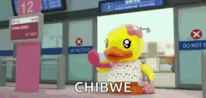 a yellow rubber duck is standing in front of a sign that says international arrivals