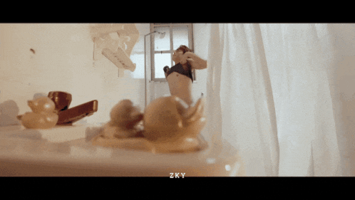 a woman is taking a shower in a bathroom with zky written below her