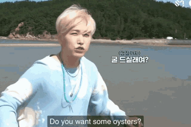 a man in a blue tie dye sweater says do you want some oysters in a foreign language