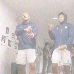 two men are standing next to each other in a hallway and one of them is wearing a nike jacket