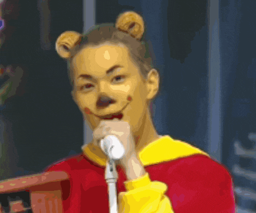 a man dressed as winnie the pooh is singing into a microphone