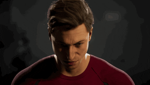 a man with green eyes and a red shirt looks at the camera