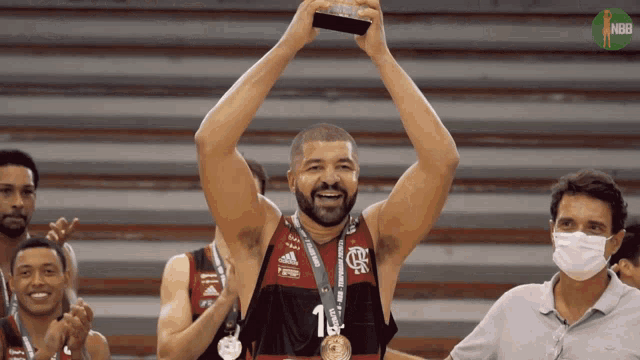 a basketball player with the number 1 on his jersey holds up a trophy