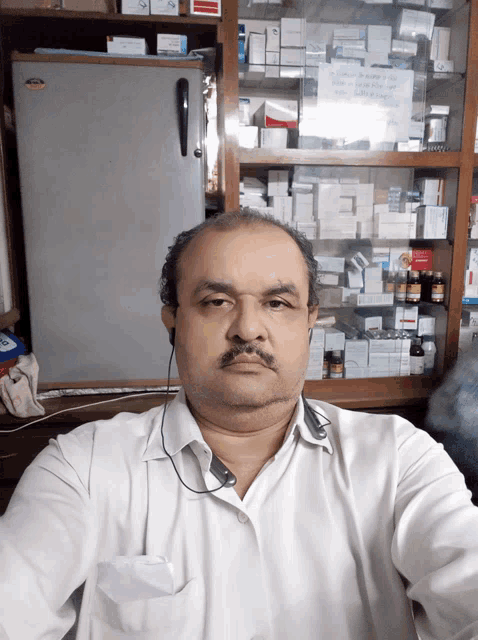 a man taking a selfie in front of a medicine cabinet with a sign that says ' ambulance ' on it