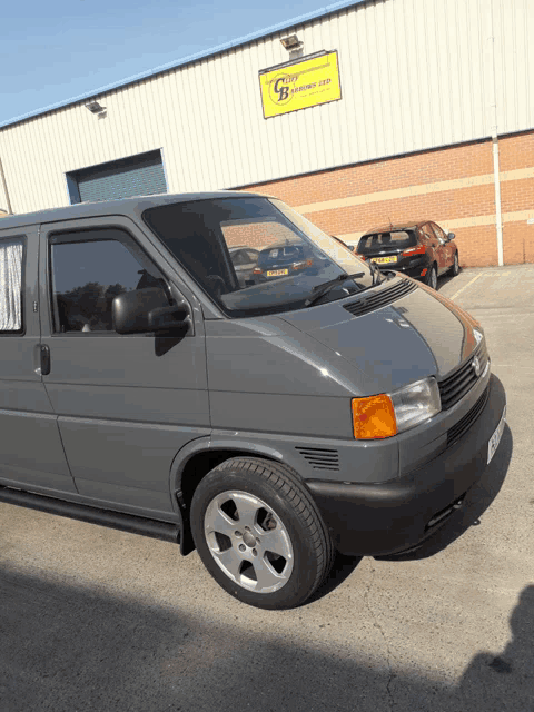 a gray van is parked in front of a building with a sign that says cliff business ltd.