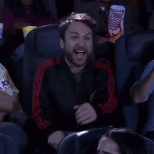 a man is laughing while sitting in a movie theater