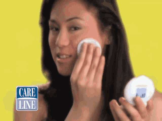 a woman wipes her face with a cotton pad while holding a bottle of care line