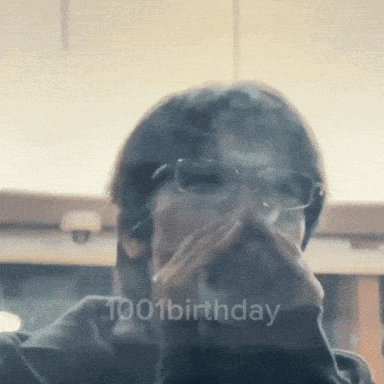 a man wearing glasses is covering his mouth with his hand and the words 1001 birthday are visible in the corner