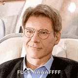 a man wearing glasses is sitting on a plane and making a funny face .