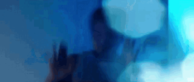 a blurry picture of a person 's face behind a glass wall .
