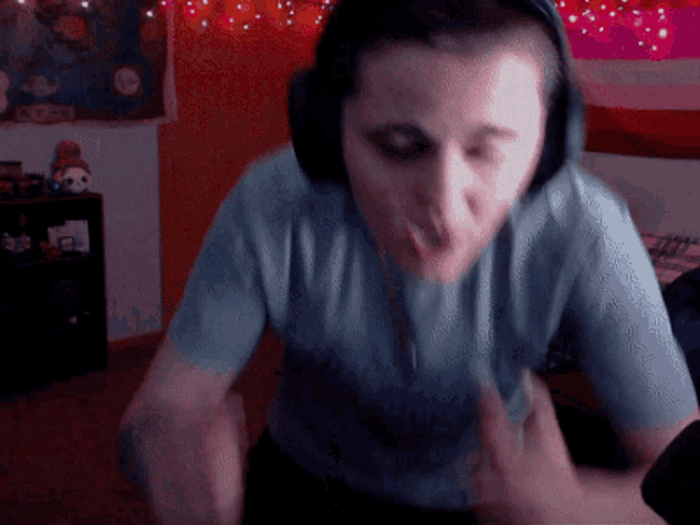 a man wearing headphones and a blue shirt is making a face